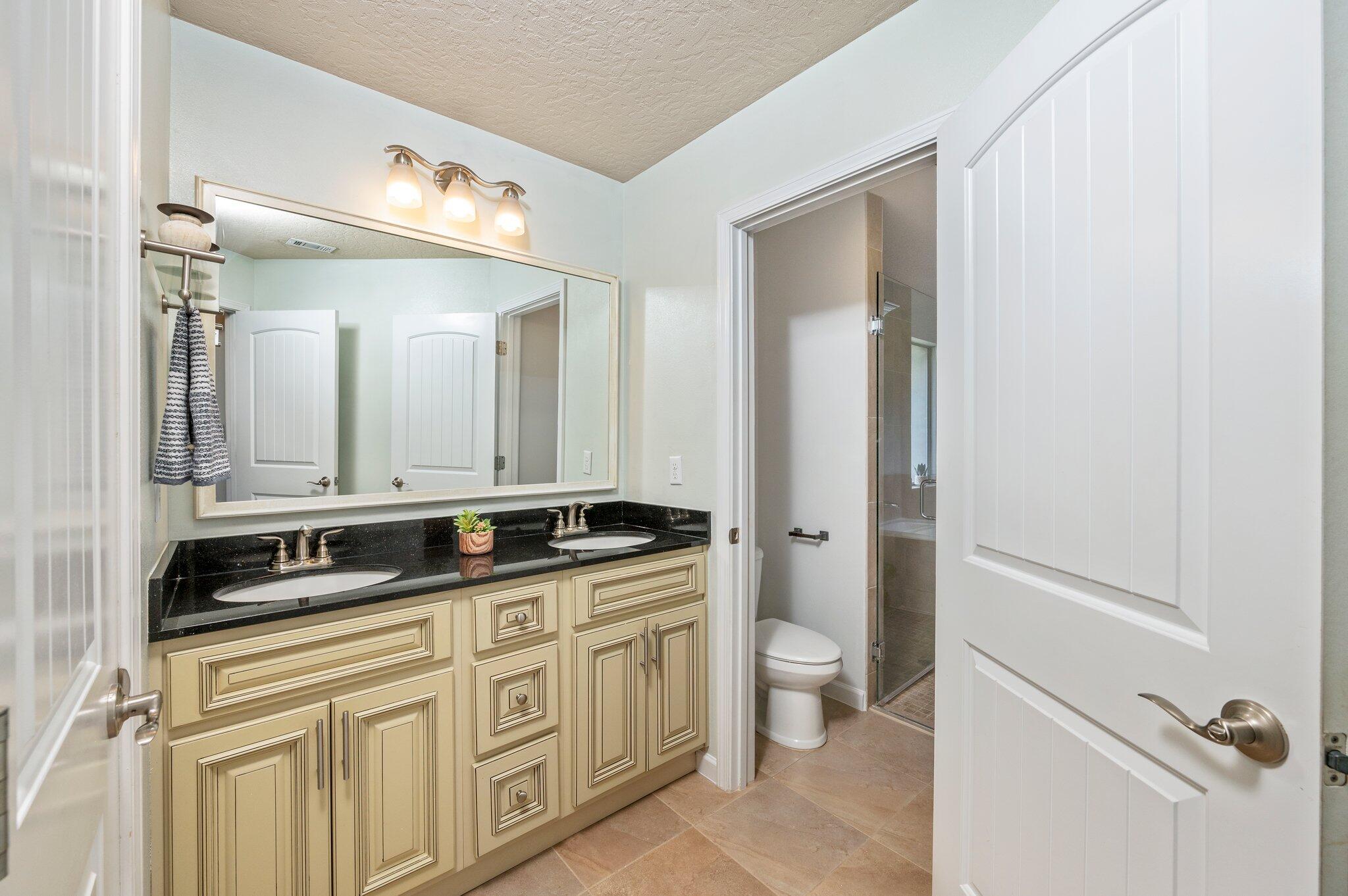 5280 Moore Loop Crestview, FL 32536 - Photo 29 of 54 a bathroom with a granite countertop sink two mirror and a toilet
