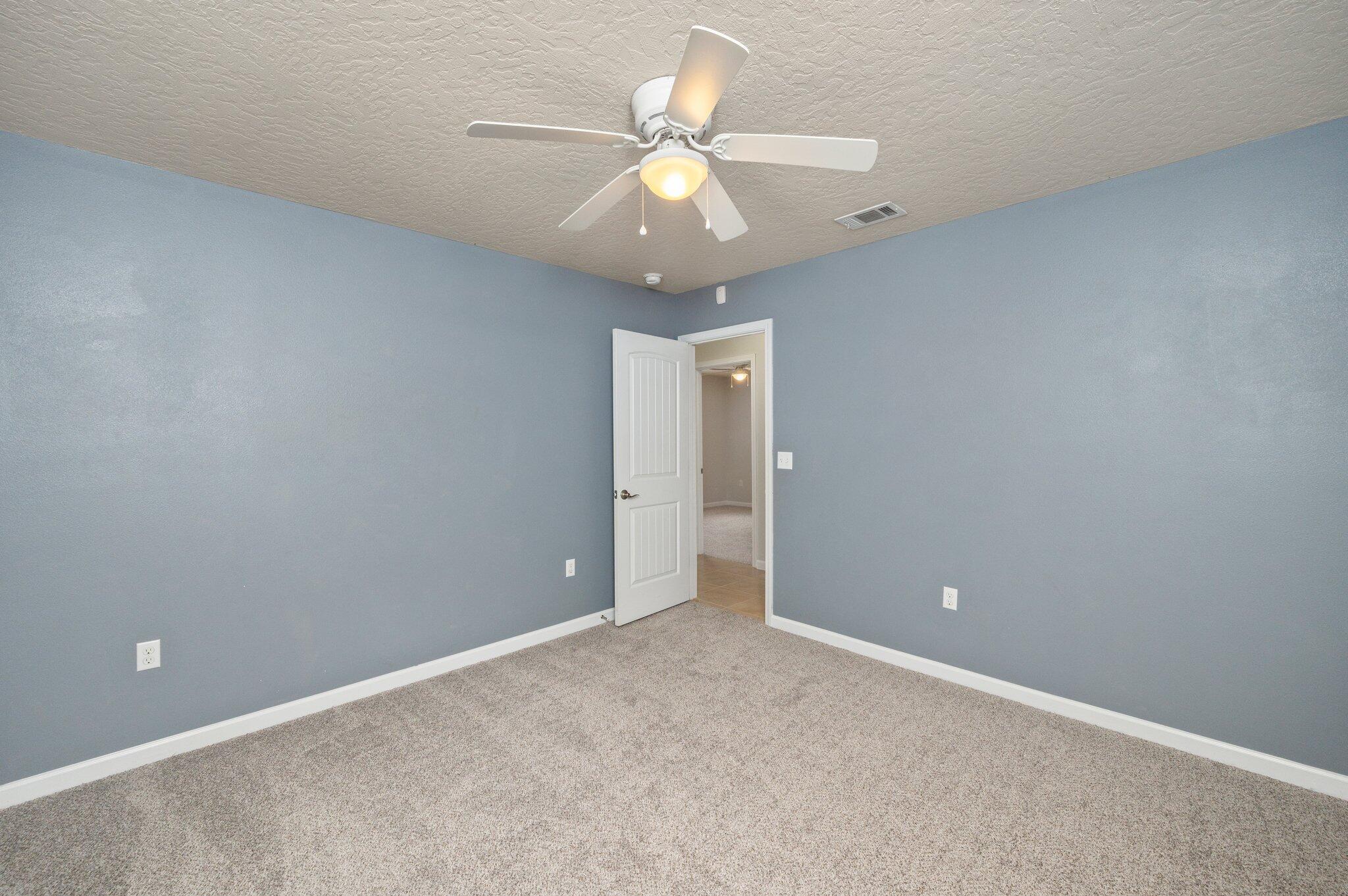 5280 Moore Loop Crestview, FL 32536 - Photo 39 of 54 an empty room with a chandelier fan and windows