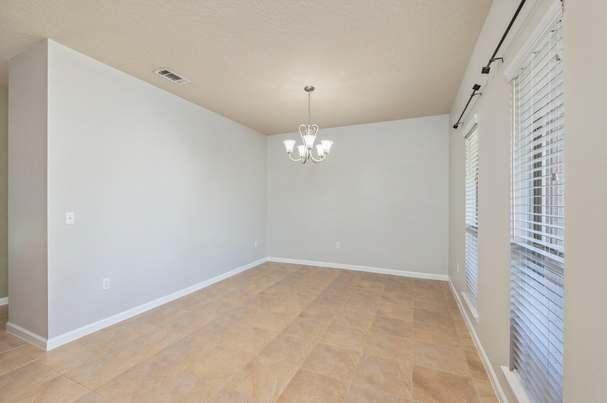 5280 Moore Loop Crestview, FL 32536 - Photo 8 of 54 an empty room with chandelier fan and windows