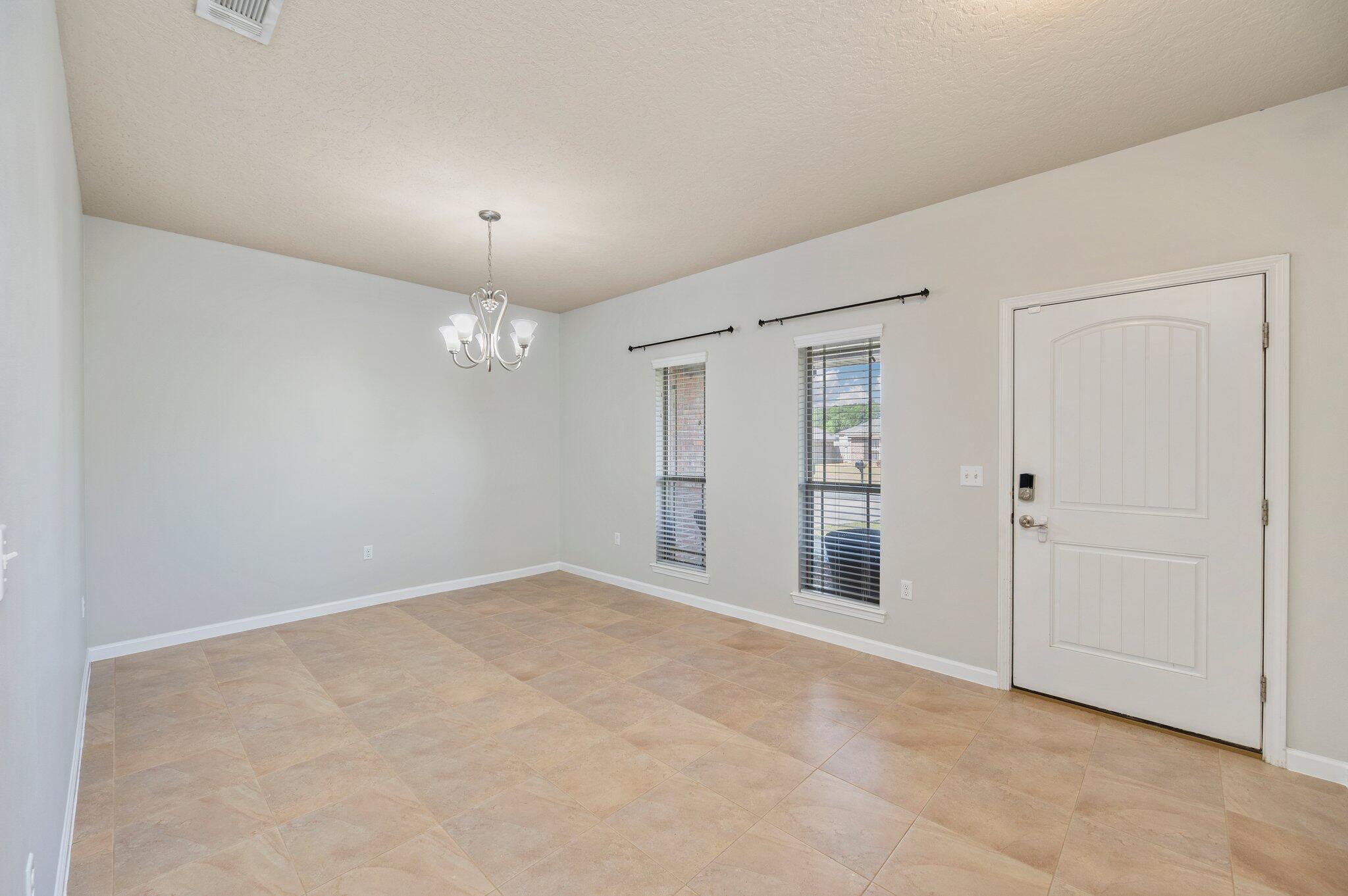5280 Moore Loop Crestview, FL 32536 - Photo 9 of 54 an empty room with chandelier fan and windows