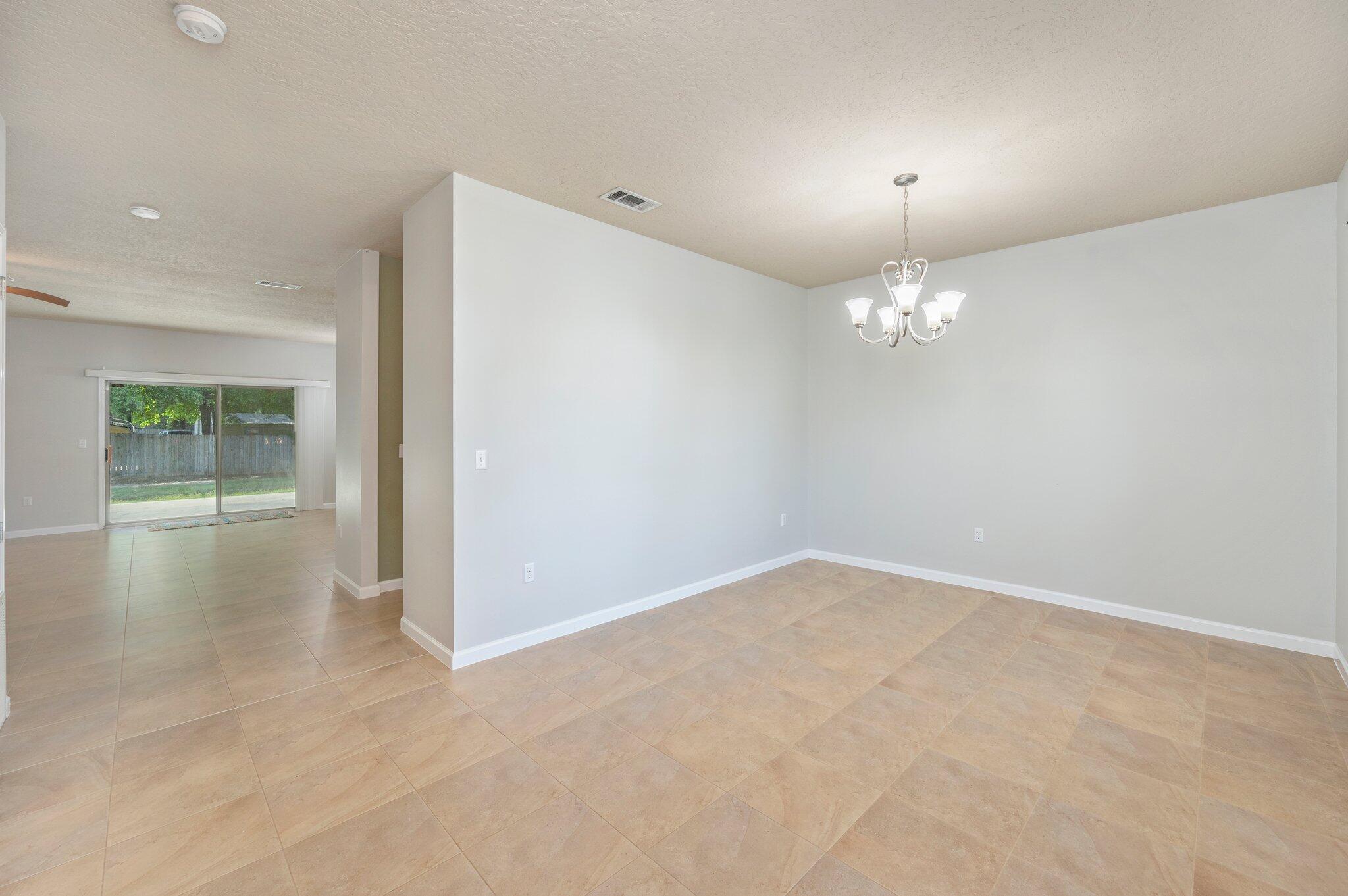 5280 Moore Loop Crestview, FL 32536 - Photo 10 of 54 an empty room with chandelier fan and windows