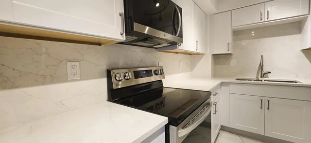 a kitchen with a stove cabinets and wooden floor