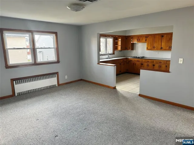 a view of kitchen with granite countertop sink and cabinets
