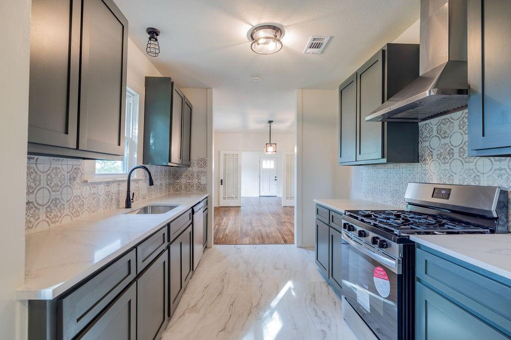 711 Fannin Street Nocona, TX 76255 - Photo 11 of 35 a kitchen with stainless steel appliances granite countertop a sink stove and refrigerator
