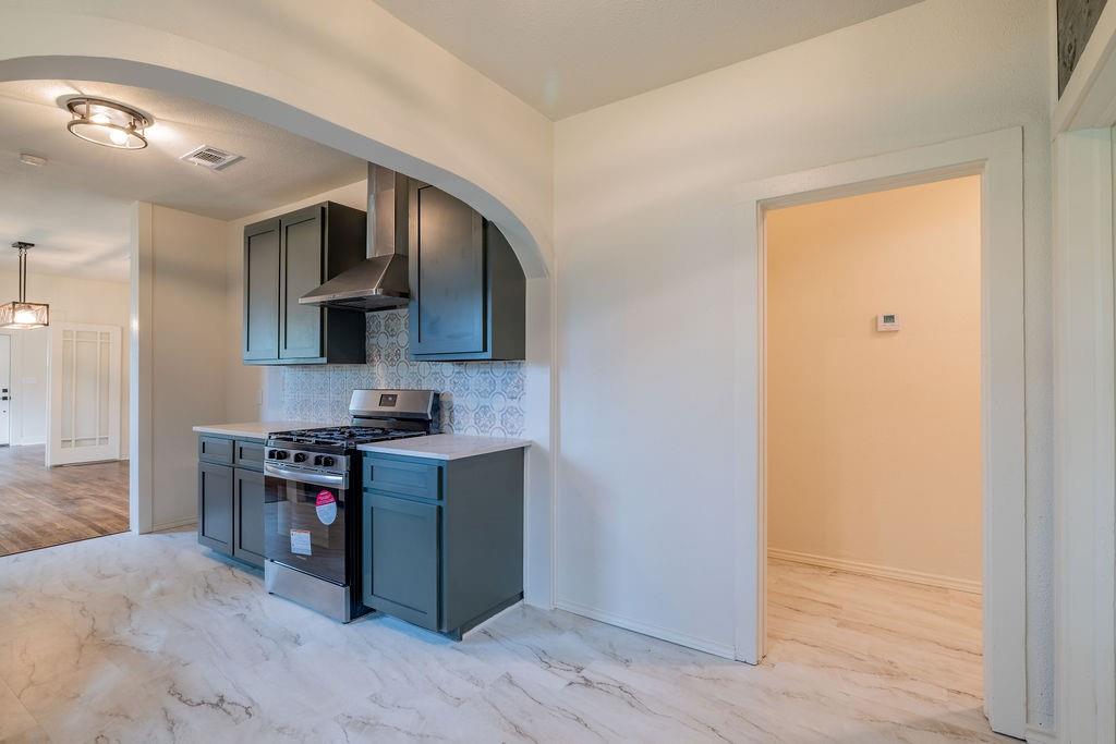 711 Fannin Street Nocona, TX 76255 - Photo 14 of 35 a kitchen with stainless steel appliances granite countertop a stove and a sink