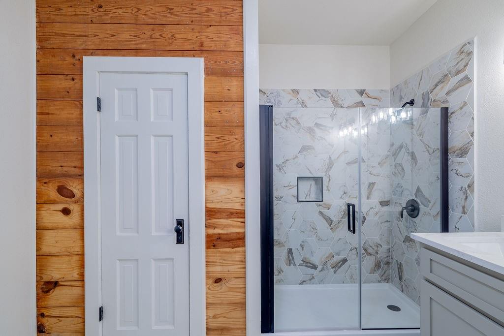 711 Fannin Street Nocona, TX 76255 - Photo 19 of 35 a bathroom with a glass shower door and a bathroom