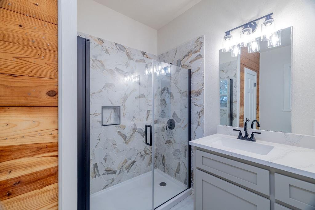 711 Fannin Street Nocona, TX 76255 - Photo 21 of 35 a bathroom with a shower sink and mirror