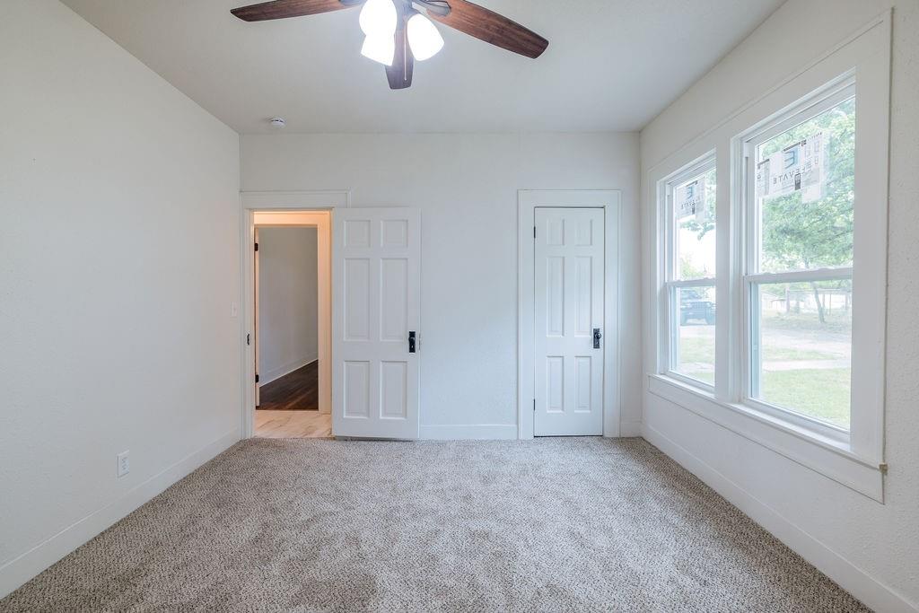 711 Fannin Street Nocona, TX 76255 - Photo 27 of 35 an empty room with chandelier fan and windows
