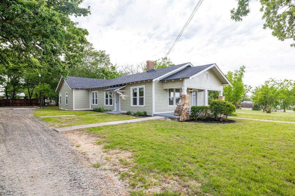 711 Fannin Street Nocona, TX 76255 - Photo 31 of 35 a view of a house with a big yard and large trees