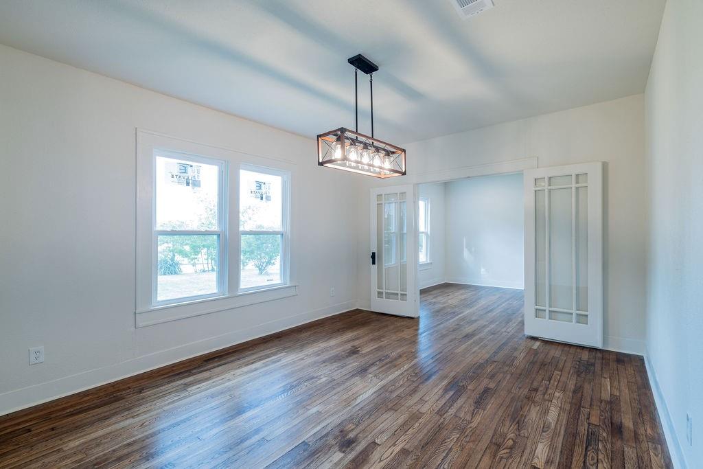 711 Fannin Street Nocona, TX 76255 - Photo 9 of 35 a view of an empty room with wooden floor and a window