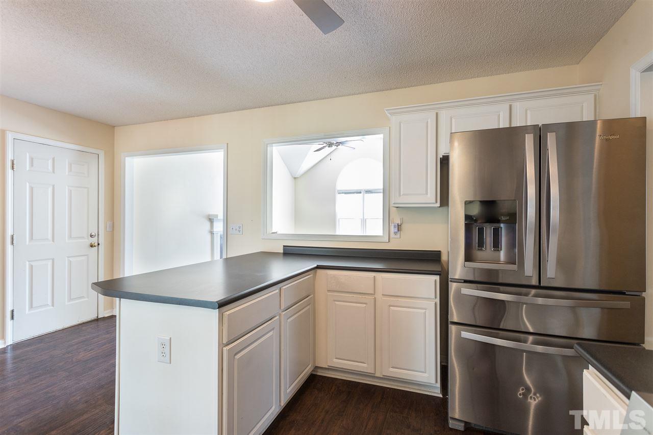 2100 Havering Place Raleigh, NC 27604 - Photo 11 of 27 a kitchen with white cabinets and stainless steel appliances