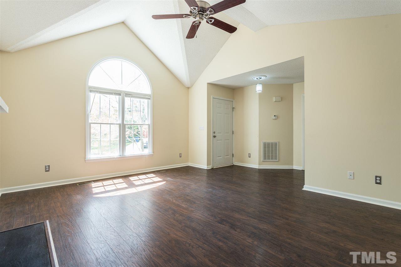 2100 Havering Place Raleigh, NC 27604 - Photo 6 of 27 an empty room with wooden floor chandelier fan and windows