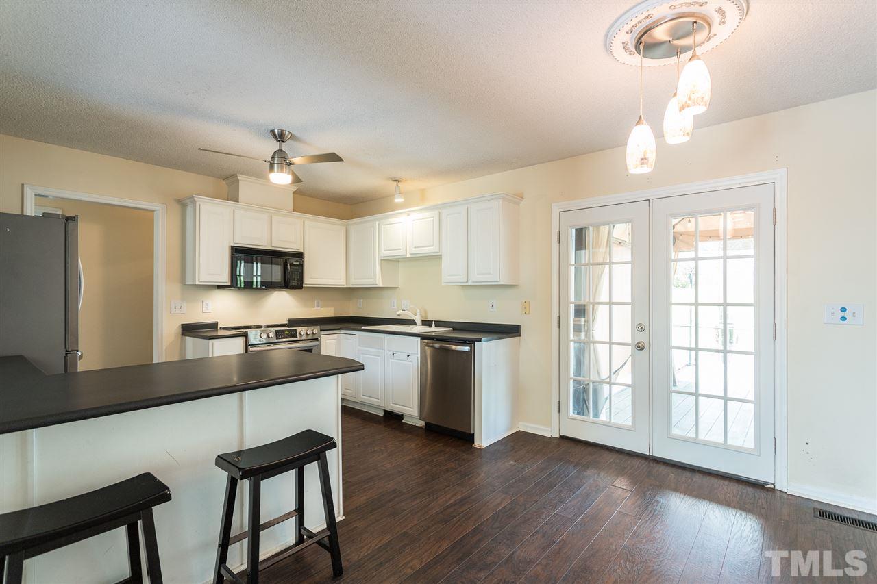 2100 Havering Place Raleigh, NC 27604 - Photo 7 of 27 a large kitchen with cabinets a sink a window and stainless steel appliances