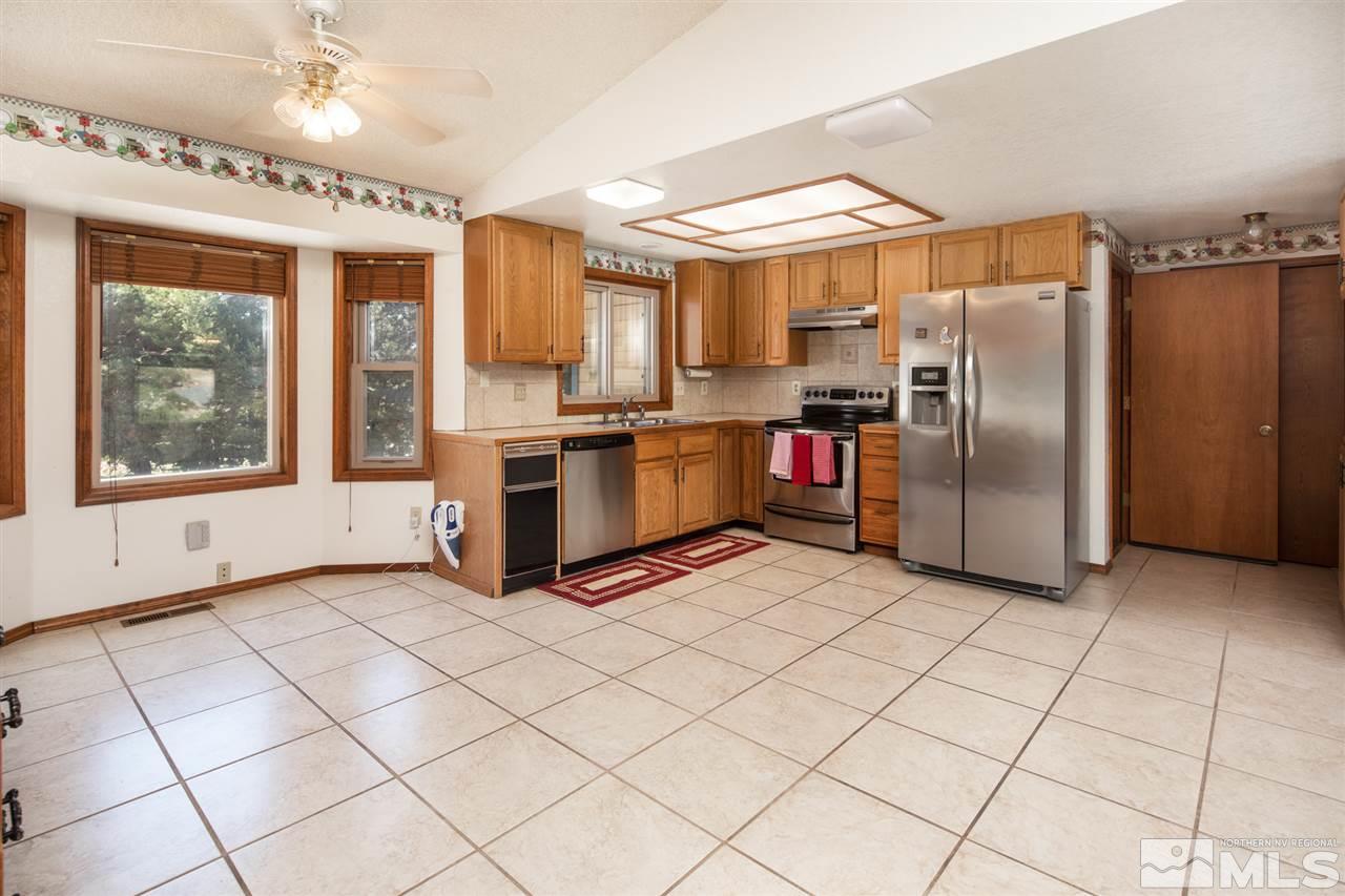 855 Lampe Road Reno, NV 89511 - Photo 5 of 30 a kitchen with stainless steel appliances granite countertop a refrigerator and a stove top oven