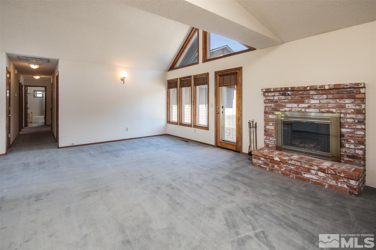 855 Lampe Road Reno, NV 89511 - Photo 7 of 30 an empty room with fireplace and windows