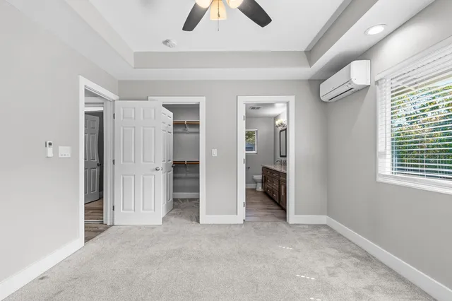 an empty room with windows and fan