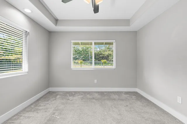 a bathroom with a granite countertop sink a mirror and a toilet