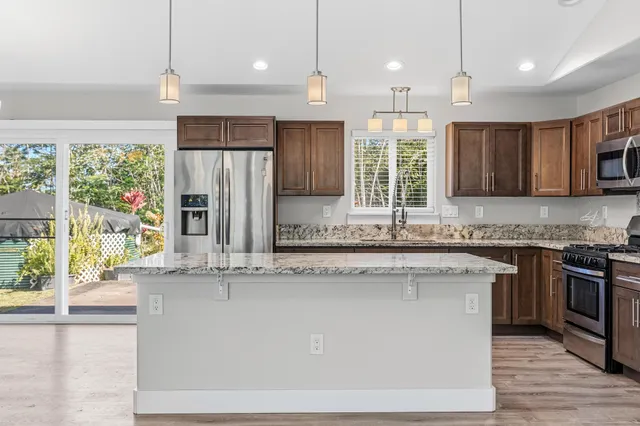 a kitchen with granite countertop wooden cabinets a sink and a window