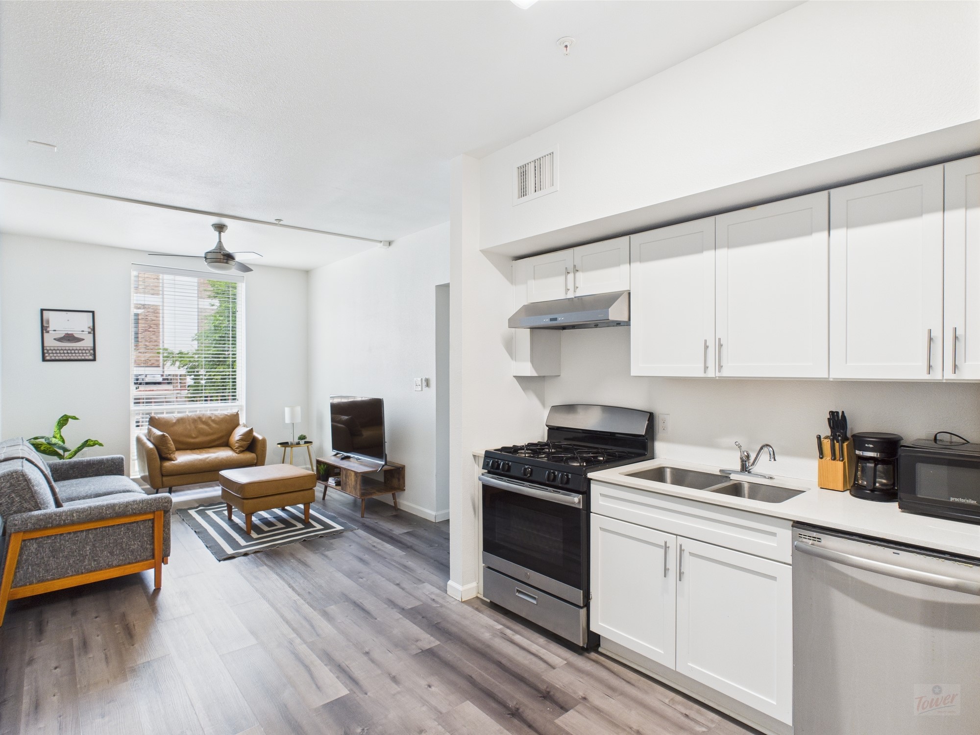 911 West 22nd Street, Unit 201 Austin, TX 78705 - Photo 1 of 1 a kitchen with stainless steel appliances granite countertop a stove and white cabinets with wooden floor