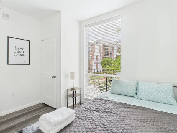 a bedroom with a bed and wooden floor