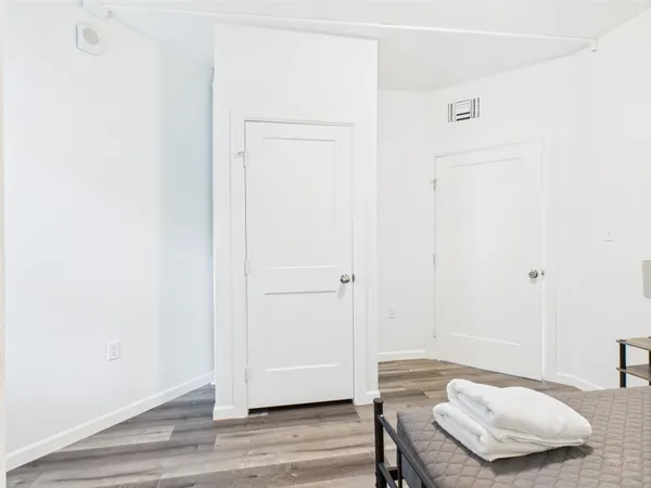 a bedroom with a bed and wooden floor