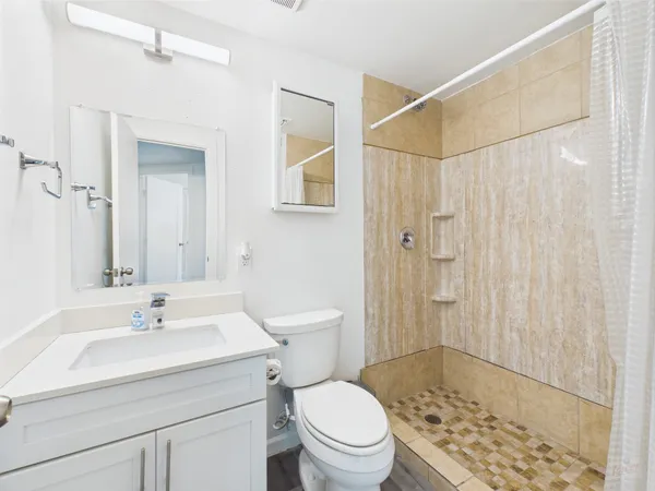 a bathroom with a sink a toilet and shower