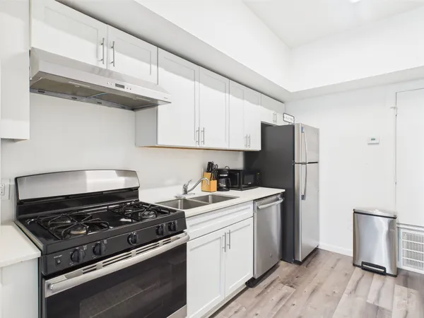 a kitchen with a stove a refrigerator and a sink
