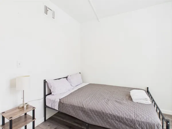 a bedroom with a bed and a night stand