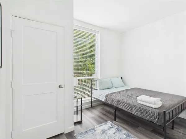 a bedroom with a bed and wooden floor