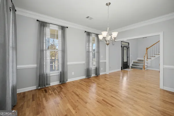 a view of a livingroom with wooden floor and a chandelier