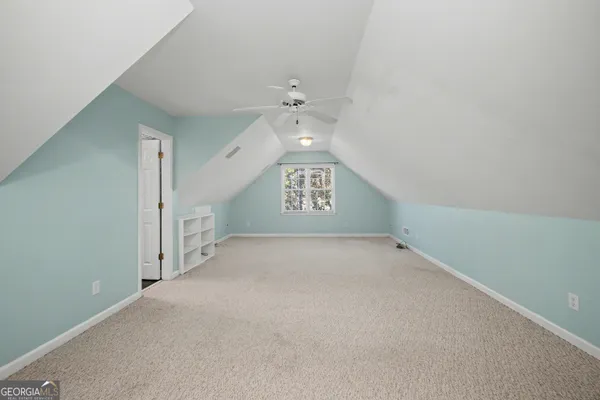 a view of an empty room with a chandelier fan