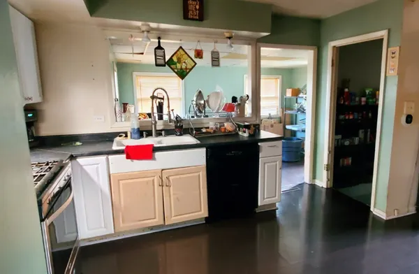 a kitchen with a stove and a wooden floor