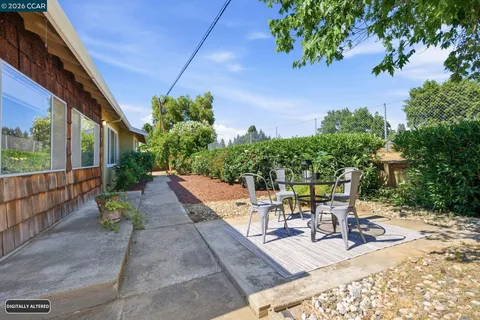 a view of a patio with table and chairs potted plants with wooden fence