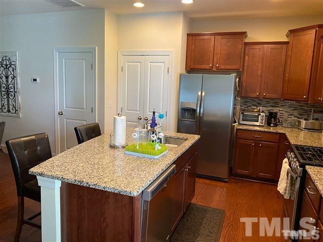 2424 Pecan Ridge Way Apex, NC 27502 - Photo 4 of 9 a kitchen with stainless steel appliances granite countertop a sink a stove and a refrigerator