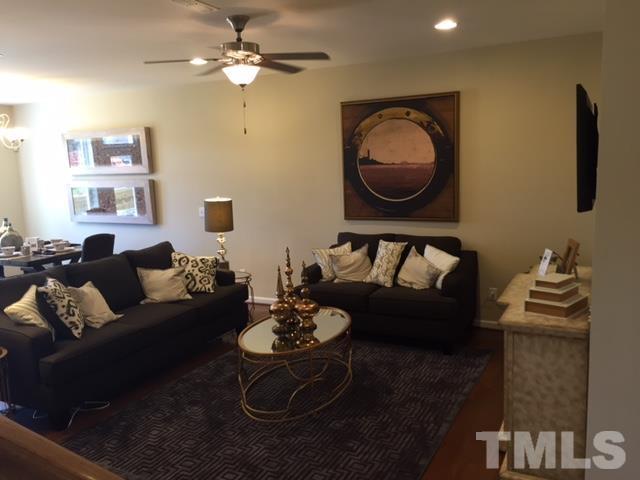 2424 Pecan Ridge Way Apex, NC 27502 - Photo 8 of 9 a living room with furniture a rug and wall paintings