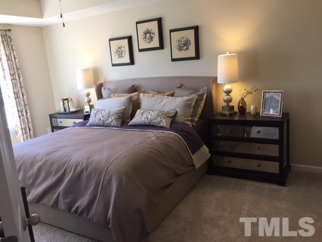 2424 Pecan Ridge Way Apex, NC 27502 - Photo 9 of 9 a bed sitting in a bedroom with a lamp