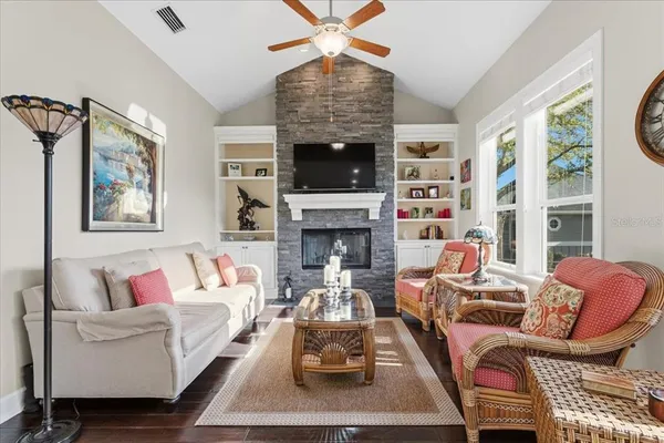 a living room with furniture a flat screen tv and a large window
