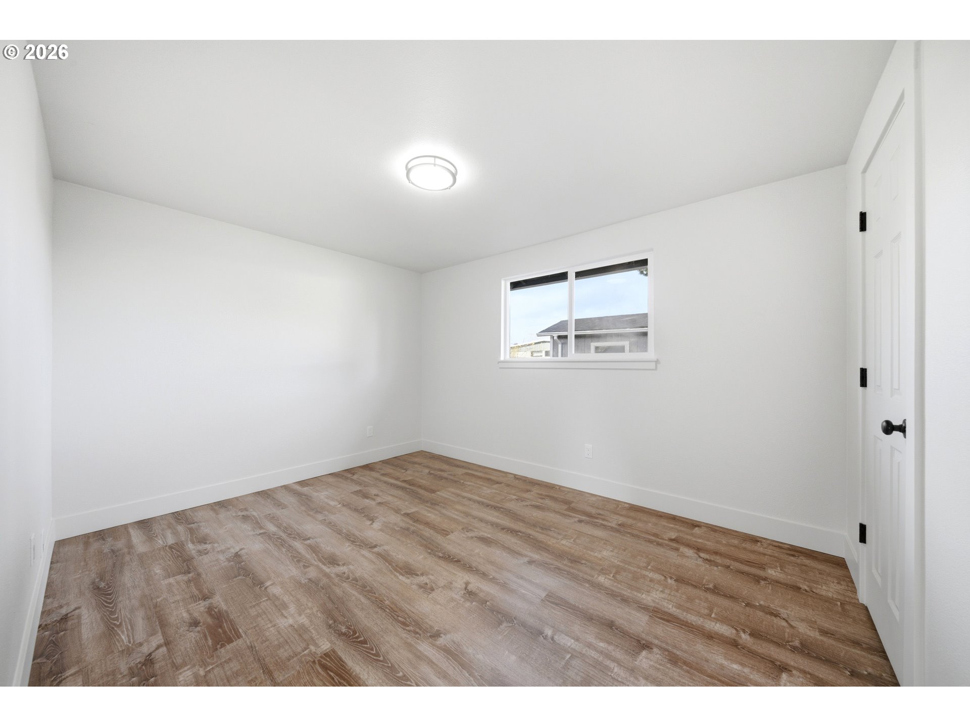 879 North Broadway Street Estacada, OR 97023 - Photo 16 of 37 a view of an empty room with wooden floor and a window