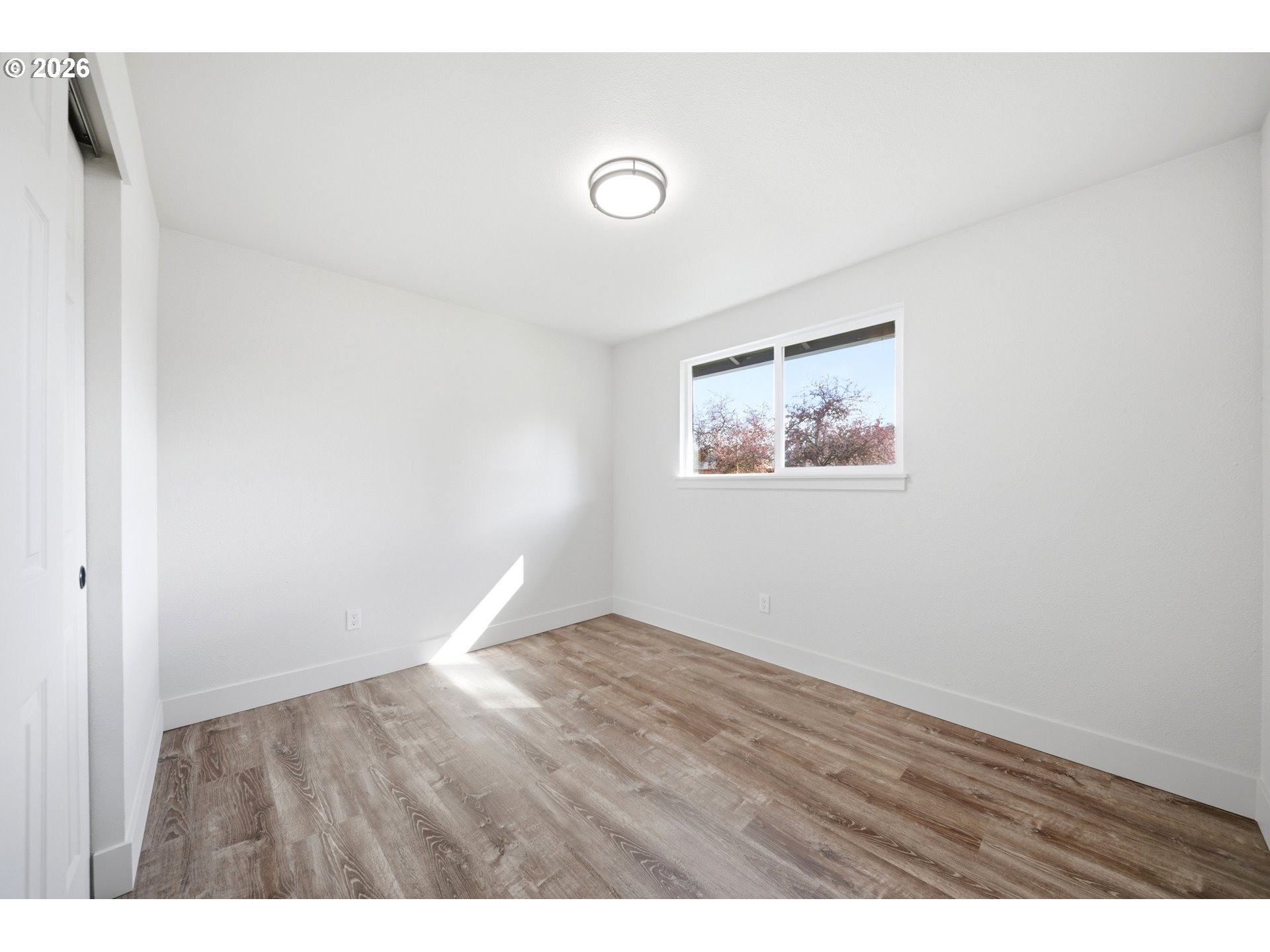 879 North Broadway Street Estacada, OR 97023 - Photo 19 of 37 a view of an empty room with wooden floor and a window