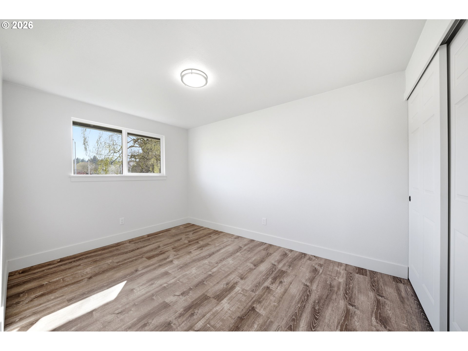 879 North Broadway Street Estacada, OR 97023 - Photo 20 of 37 a view of an empty room with wooden floor and a window