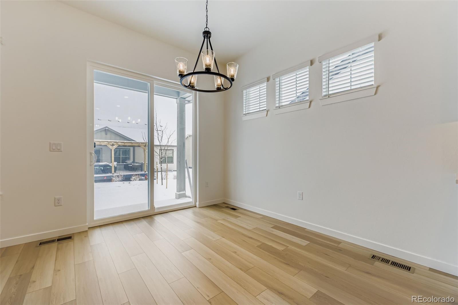 8905 South Riviera Way Aurora, CO 80016 - Photo 12 of 27 a view of an empty room with wooden floor and a window