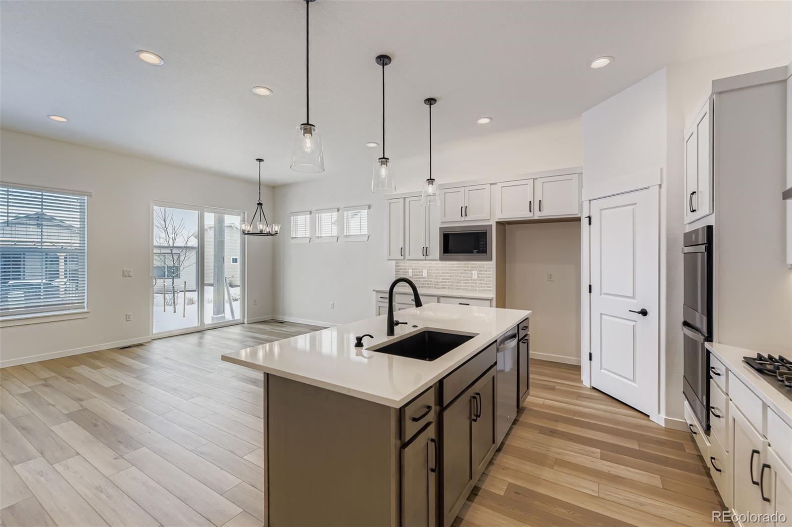 8905 South Riviera Way Aurora, CO 80016 - Photo 8 of 27 a kitchen with kitchen island granite countertop a sink and refrigerator