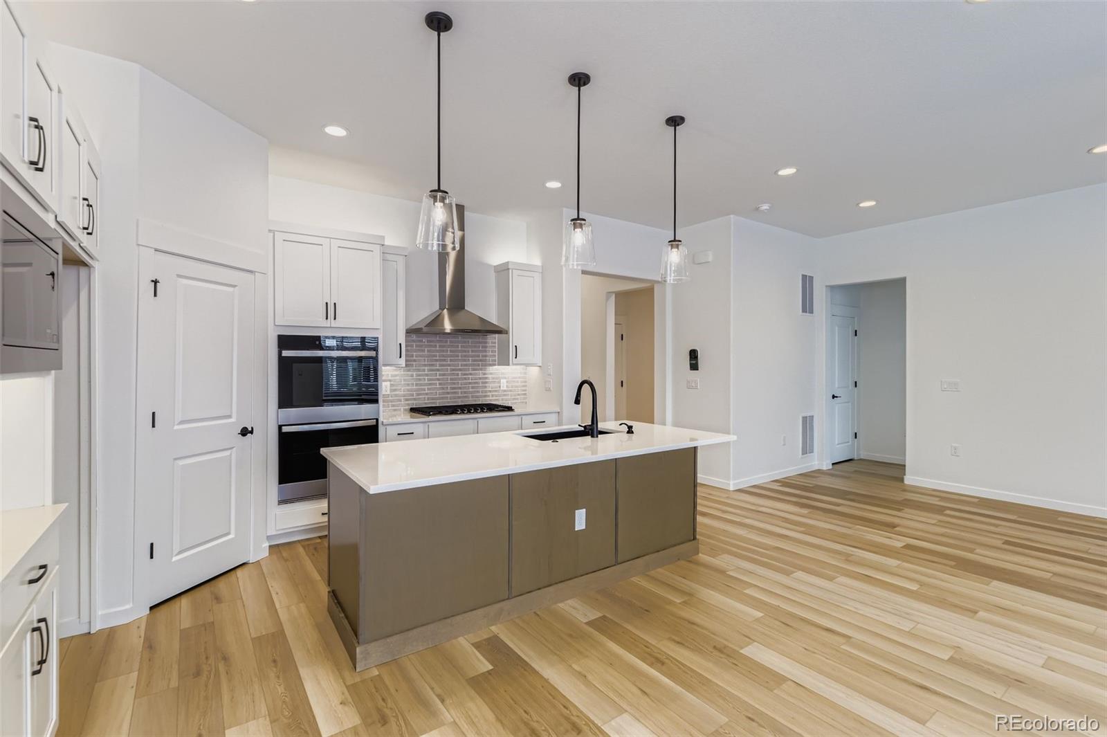 8905 South Riviera Way Aurora, CO 80016 - Photo 10 of 27 a large kitchen with kitchen island a stove a sink a refrigerator a center island a stove and a refrigerator