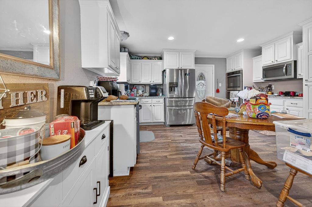 9474 Fm 804 Larue, TX 75770 - Photo 19 of 25 a kitchen with stainless steel appliances kitchen island granite countertop a refrigerator a stove a sink a dining table and chairs with wooden floor