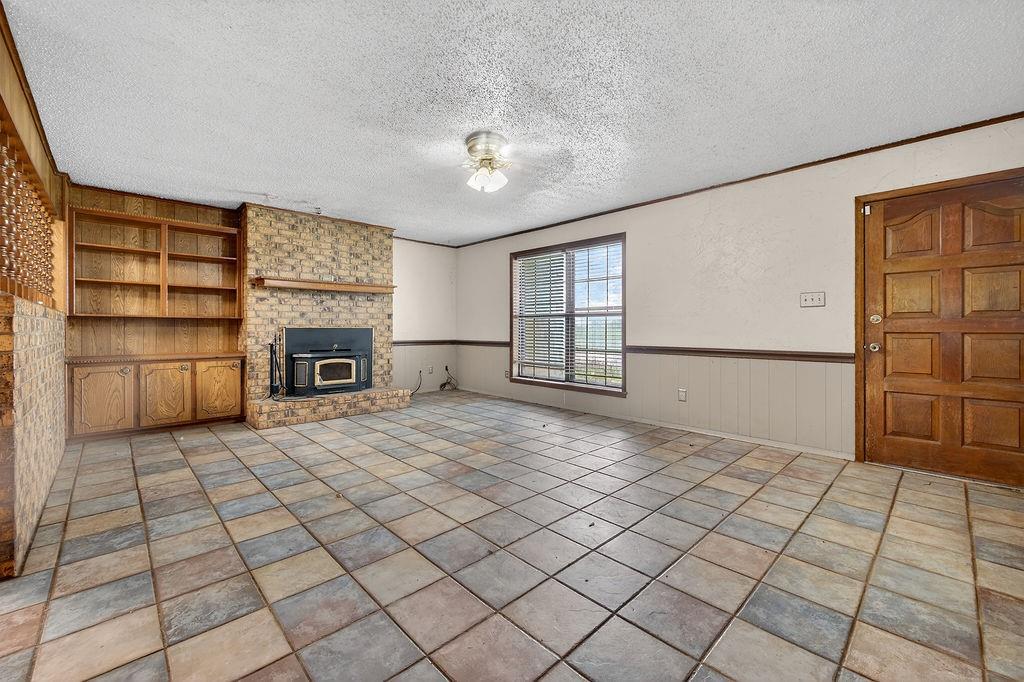 9474 Fm 804 Larue, TX 75770 - Photo 3 of 25 a view of an empty room with a fireplace and a window