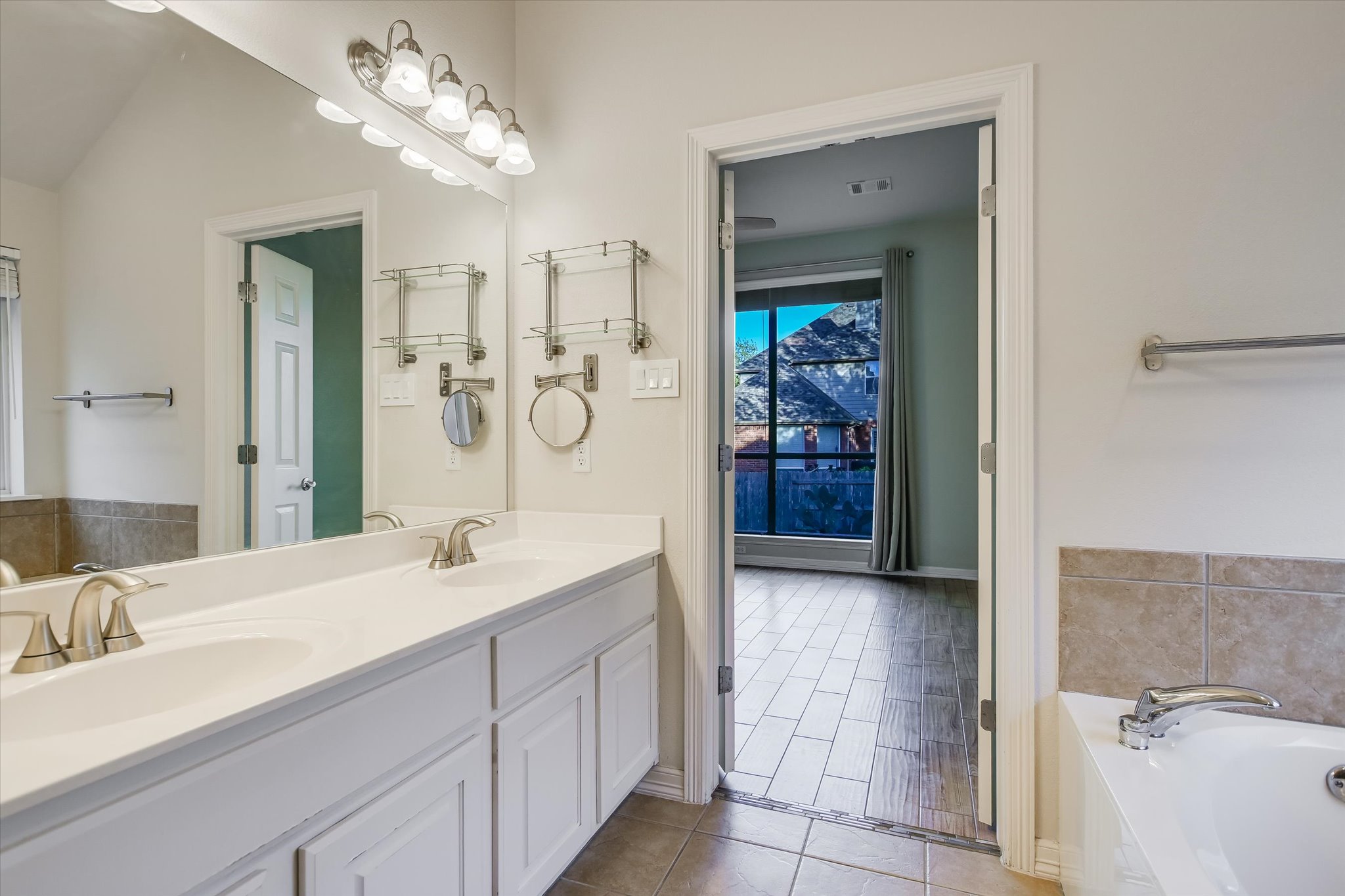 2300 Village View Loop Pflugerville, TX 78660 - Photo 11 of 25 a spacious bathroom with a double vanity sink a large mirror and a shower