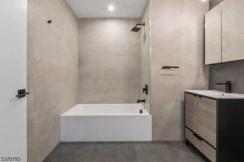 65 McWhorter Street, Unit 705 Newark, NJ 07105 - Photo 19 of 28 a bathroom with a bathtub and shower