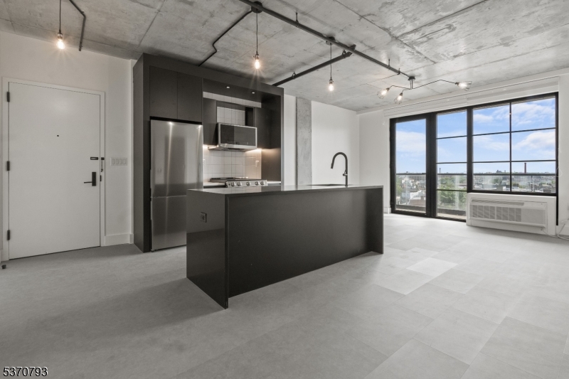 65 McWhorter Street, Unit 705 Newark, NJ 07105 - Photo 8 of 28 a large kitchen with stainless steel appliances granite countertop a refrigerator and a sink
