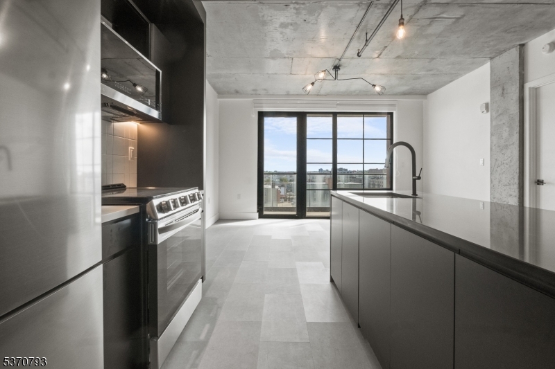 65 McWhorter Street, Unit 705 Newark, NJ 07105 - Photo 10 of 28 a kitchen with granite countertop a refrigerator stove and sink