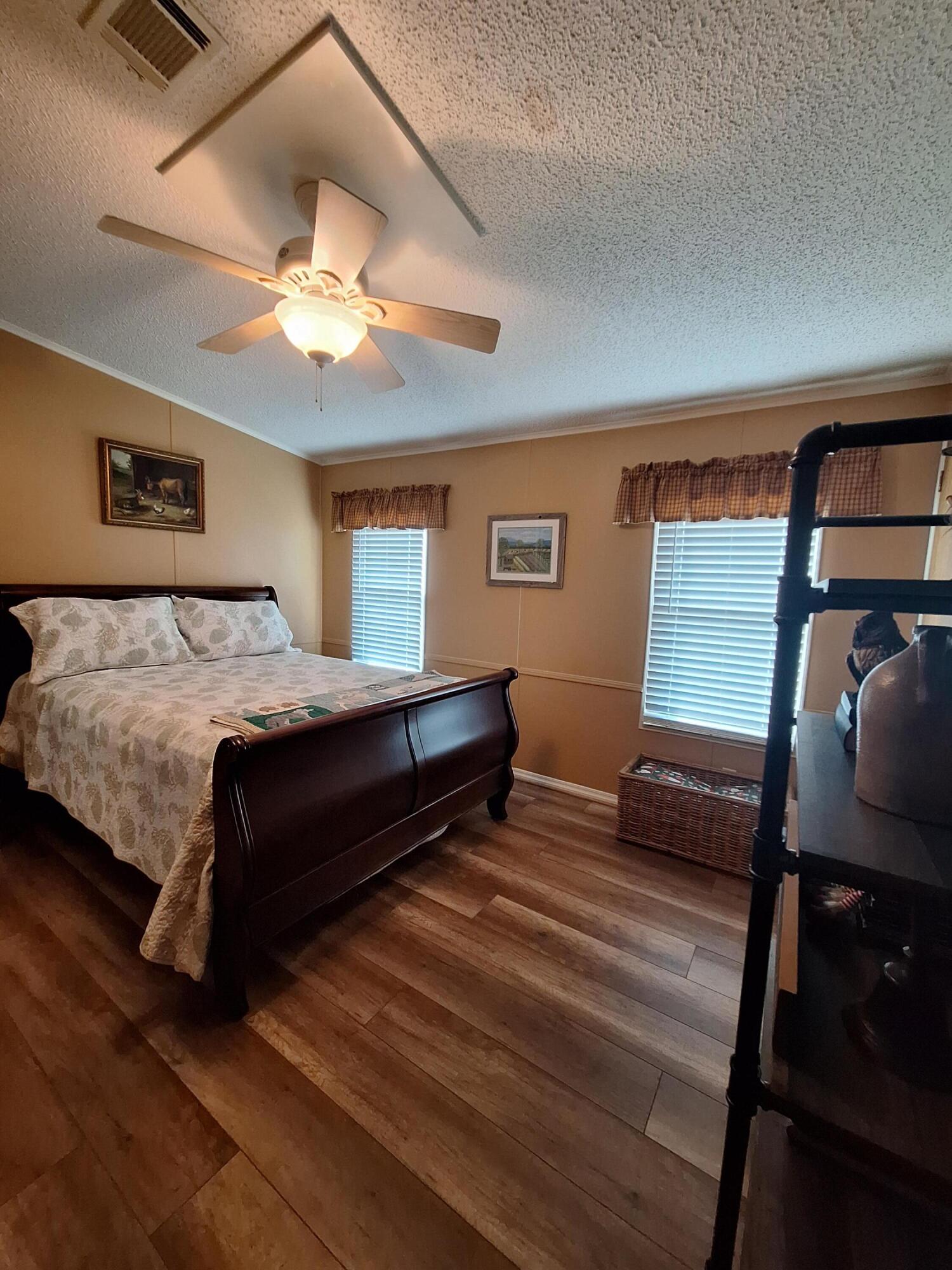 846 Periwinkle Circle Barefoot Bay, FL 32976 - Photo 13 of 23 a bedroom with a bed and a chandelier